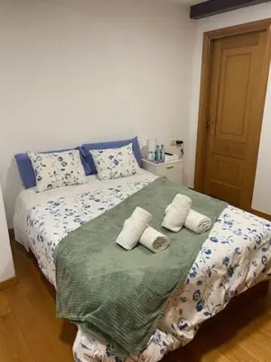a bedroom with a bed with towels on it at Entrepraciñas A in Santiago de Compostela
