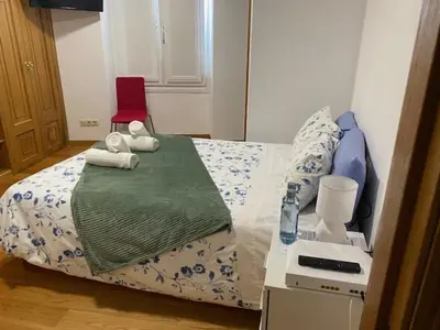 a bedroom with a bed with towels on it at Entrepraciñas A in Santiago de Compostela