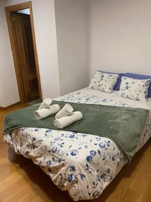a bedroom with a bed with towels on it at Entrepraciñas A in Santiago de Compostela