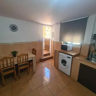 a kitchen with a table and a washing machine at Villa Mallorquina tu zona para desconectar