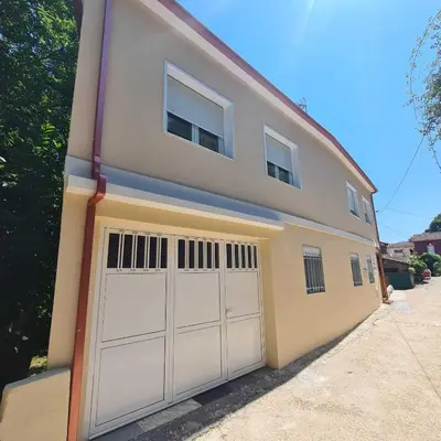 a house with two garage doors on the side of it at Villa Mallorquina tu zona para desconectar