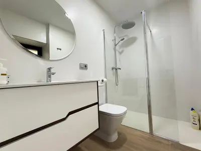 a white bathroom with a toilet and a mirror at Casa Aldea de Piñeiro, Turismo Rural Padrón by URent in Padrón