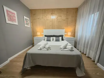 a bedroom with a bed with two towels on it at Apart Martínez Rosalía in Padrón