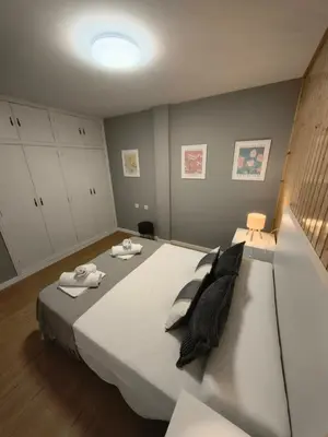 a bedroom with a large white bed with towels on it at Apart Martínez Rosalía in Padrón