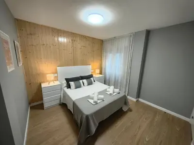 a bedroom with a bed with two candles on it at Apart Martínez Rosalía in Padrón