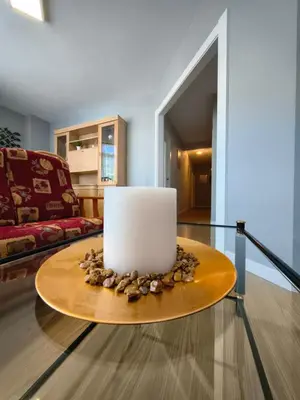a living room with a table with a candle on it at Apart Martínez Rosalía in Padrón