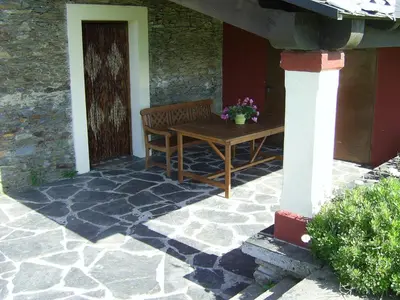 a wooden bench sitting on the porch of a house at Casa Fonso in Villapedre
