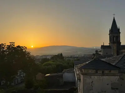 a sunset over a city with a church at Albergue Internacional in Sarria
