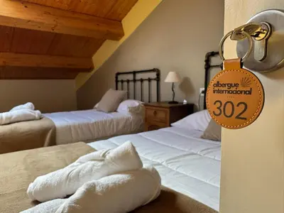 a room with two beds with a price tag on the door at Albergue Internacional in Sarria