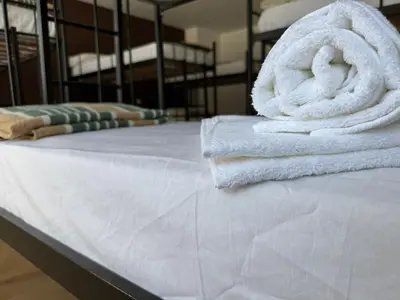 a stack of towels sitting on top of a bed at Albergue Internacional in Sarria