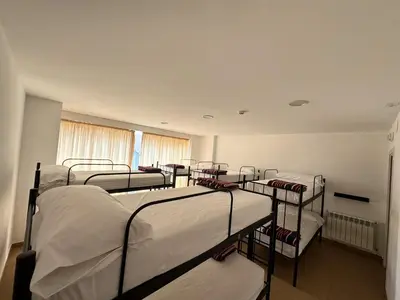a row of bunk beds in a room at Albergue Internacional in Sarria