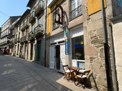 a street with two chairs and a table on a sidewalk at Albergue Internacional in Sarria