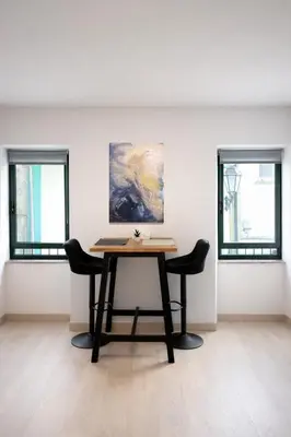 a table in a room with two windows at Apartamento Alba 1.1 in Lugo