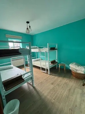 a bedroom with two bunk beds and a blue wall at ALBERGUE Pasiño A Pasiño in Portomarin