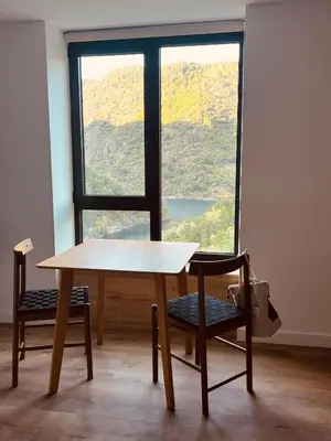a table and a chair in front of a window at Chulavista House by Kev in Parada del Sil