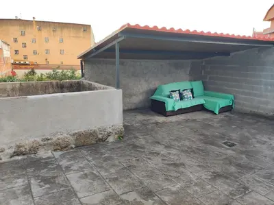 a green couch sitting on a rooftop patio at Cesarina Urban House in Chantada