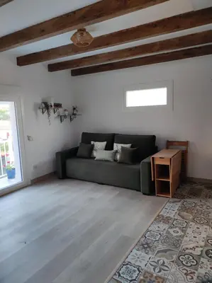 a living room with a green couch and a table at Cesarina Urban House in Chantada