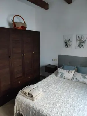 a bedroom with a bed and a dresser with a basket on it at Cesarina Urban House in Chantada