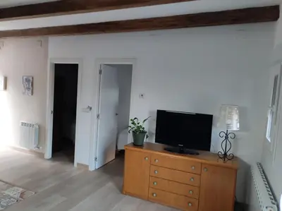 a living room with a television on a wooden dresser at Cesarina Urban House in Chantada