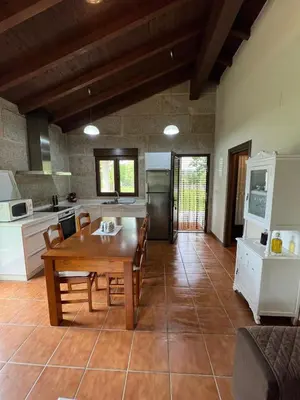 a kitchen and dining room with a wooden table and chairs at Vilaboa Paradise in Villanueva