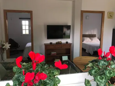 a living room with red flowers in front of a mirror at Cafú Casita in Coirós