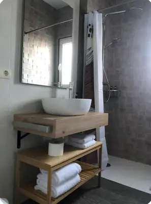 a bathroom with a counter with a sink and a shower at Cafú Casita in Coirós
