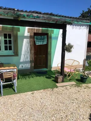 a house with a door and a chair and a table at Cafú Casita in Coirós