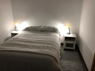 a bedroom with a bed and two lamps on two tables at Cafú Casita in Coirós