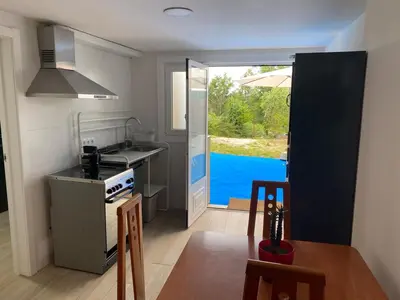 a kitchen with a sink and a stove and a table at Cafu loft in Coirós