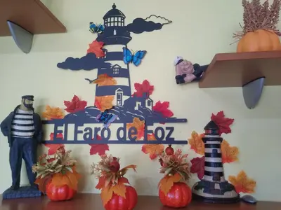 a lighthouse sign on a wall with pumpkins at El Faro de Foz!!! Excelentes vistas,Tranquilo y Luminoso in Foz