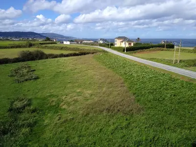 an aerial view of a field with a road at El Faro de Foz!!! Excelentes vistas,Tranquilo y Luminoso in Foz