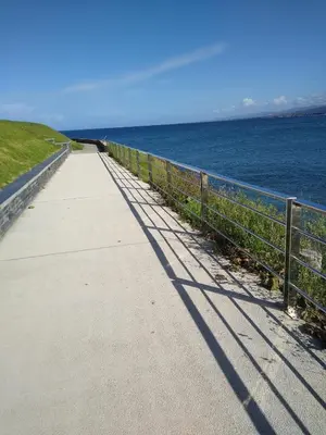 a long sidewalk next to the ocean with its shadows at El Faro de Foz!!! Excelentes vistas,Tranquilo y Luminoso in Foz