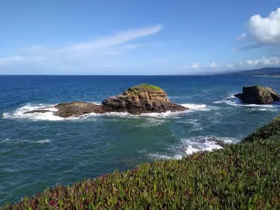 a group of rocks in the ocean near the shore at El Faro de Foz!!! Excelentes vistas,Tranquilo y Luminoso in Foz