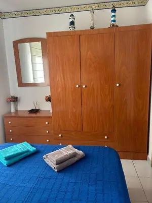 a bedroom with a blue bed and wooden cabinets at El Faro de Foz!!! Excelentes vistas,Tranquilo y Luminoso in Foz
