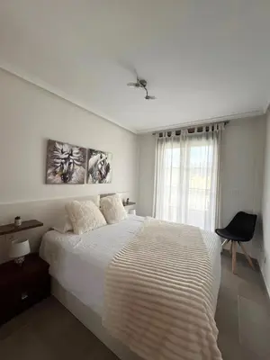 a white bedroom with a bed and a window at Amanecer en Costa Reinante Spa in San Miguel de Reinante