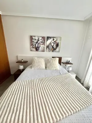 a bedroom with a large white bed with two pillows at Amanecer en Costa Reinante Spa in San Miguel de Reinante