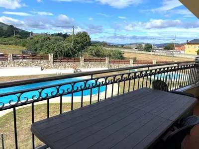 a wooden bench on a balcony with a fence at Amanecer en Costa Reinante Spa in San Miguel de Reinante