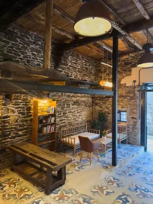 a room with a wooden bench and a brick wall at Go Compostela Apartamento 4 pax in Sarria