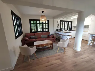a living room with a couch and chairs and a kitchen at MeraVilla in Oleiros