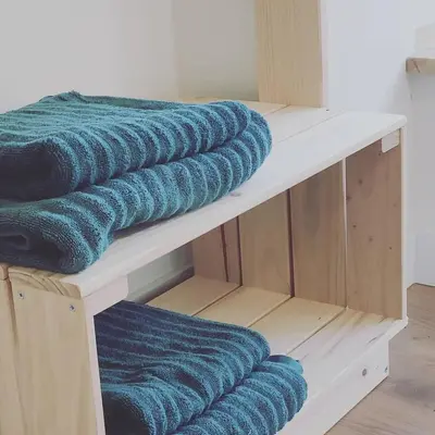 three blue towels are sitting on a shelf at MeraVilla in Oleiros