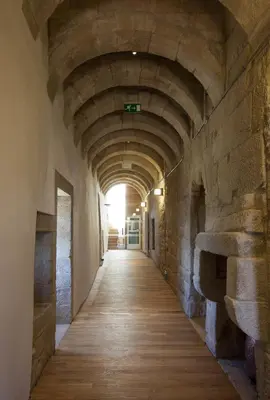 an empty hallway in an old building with a tunnel at Parador Castillo de Monterrei in Monterrei