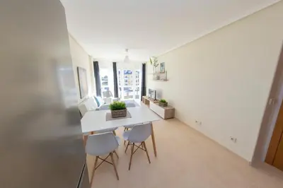 a kitchen and dining room with a white table and chairs at Apartagal-Océano V Barreiros in Barreiros