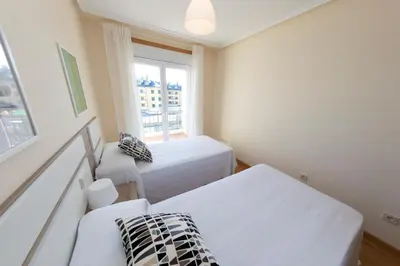 a bedroom with two beds and a window at Apartagal-Océano V Barreiros in Barreiros