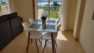 a white table and chairs in a room with a window at Apartagal-Océano V Barreiros in Barreiros
