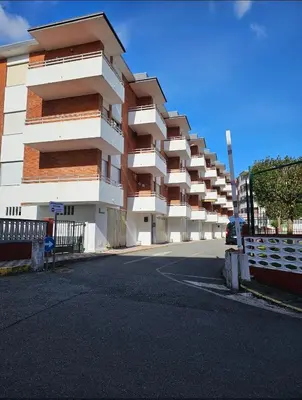 a large white building with balconies on a street at Apartamento Playa de Ber Ber-Mar in Perbes