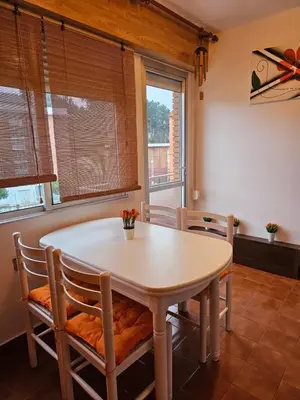 a dining room with a table and chairs and windows at Apartamento Playa de Ber Ber-Mar in Perbes