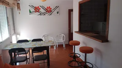 a dining room with a table and chairs and a mirror at Apartamento Playa de Ber Ber-Mar in Perbes