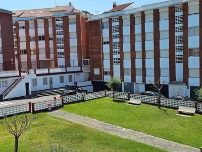 a park in front of a large brick building at Apartamento Playa de Ber Ber-Mar in Perbes