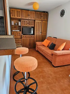 a living room with a couch and a bar stool at Apartamento Playa de Ber Ber-Mar in Perbes