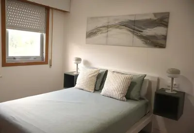 a bedroom with a bed with pillows and a window at Casa do Balneario in Arnoia